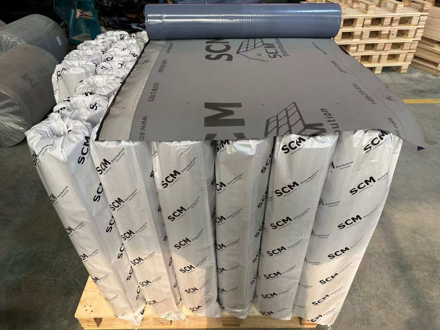 Membrane grise déroulée sur des rouleaux emballés